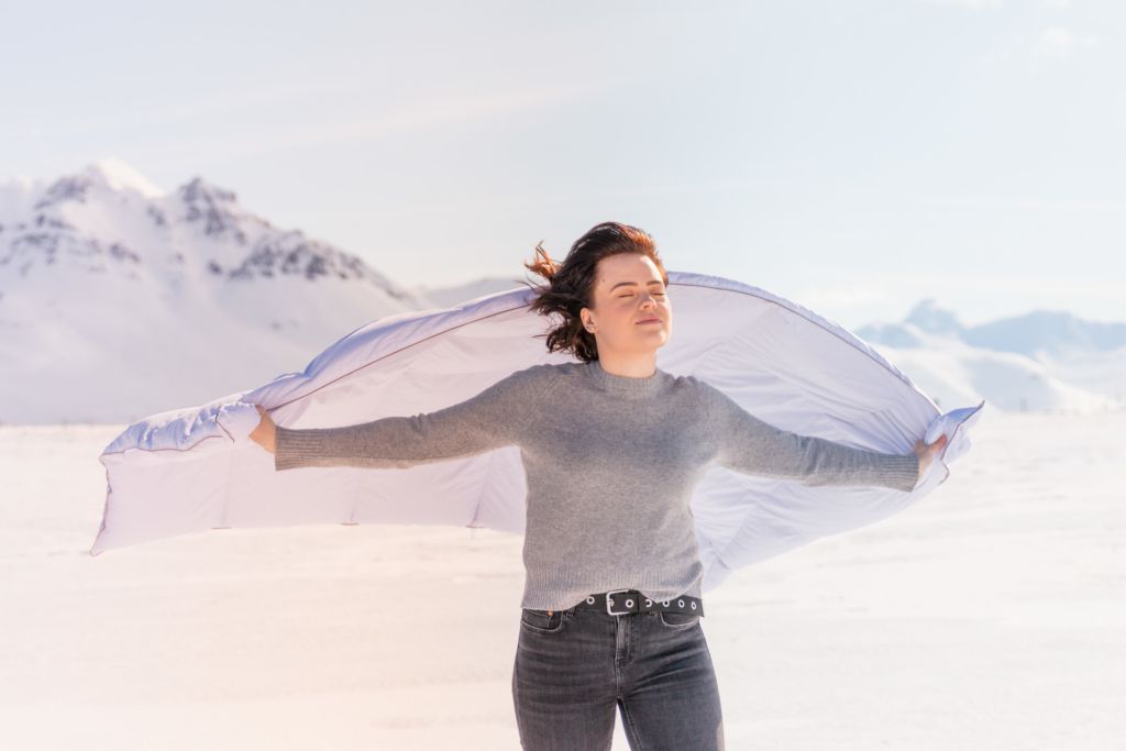 Young woman with duvet outside